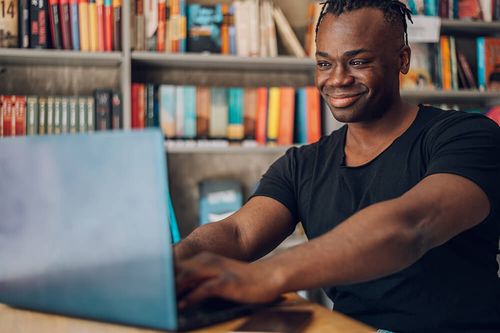 African-american-man-using-laptop-while-drinking