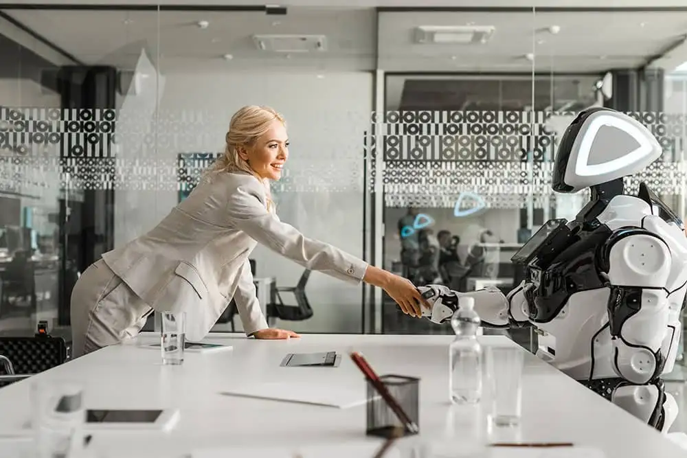 Smiling-businesswoman-shaking-hands-with-robot-sit-2022-12-16-19-16-14-utc
